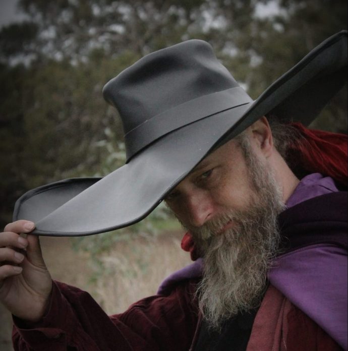 A bearded man wearing a giant leather hat.